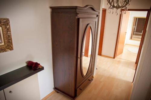 een houten kast in een kamer met een spiegel bij Casa Sofia in Friedrichshafen