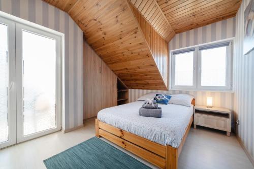 a bedroom with a bed and two windows at Pokoje Syberia Morska 20 in Kuźnica