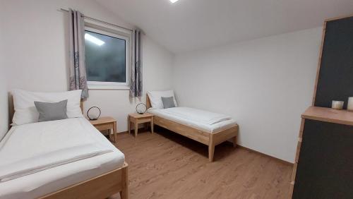 a small room with two beds and a window at URLAUB LUNZ - Ferienwohnungen Fam. Fürst in Lunz am See