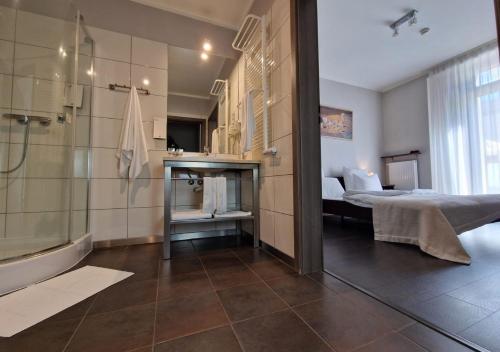 a bathroom with a shower and a bed and a tub at Hotel Grzegorzewski in Tuszyn