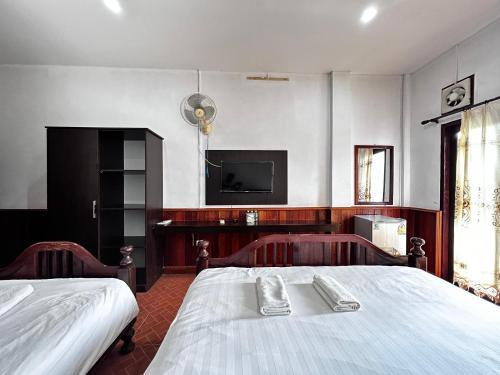 sypialnia z łóżkiem i telewizorem na ścianie w obiekcie Domon Riverside Hotel w mieście Vang Vieng