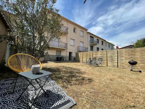 a backyard with a table and chairs and a fence at LG RITE Appartement avec jardin in Prades