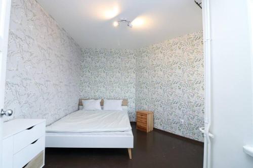 a bedroom with a white bed and floral wallpaper at City-central flat with sauna in Tallinn