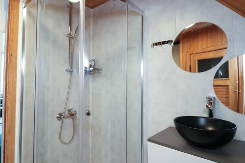 a bathroom with a shower and a black sink at City-central flat with sauna in Tallinn