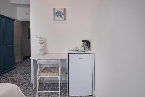 um quarto com uma mesa branca e uma cadeira em Hotel La Caravella em Agropoli