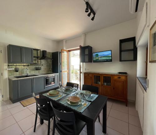 a kitchen with a black table and chairs in a room at Verdemare, Casa & Panorama - Salerno, Amalfi Coast in Salerno