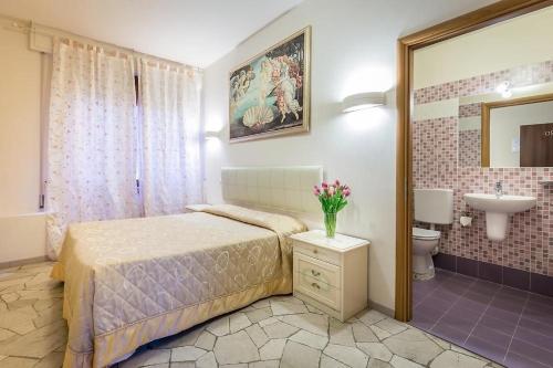 a bedroom with a bed and a bathroom with a sink at Hotel Arcadia in Florence