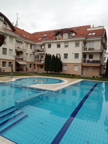 a large swimming pool in front of some buildings at Oázis Wellness Apartman2 in Hajdúszoboszló