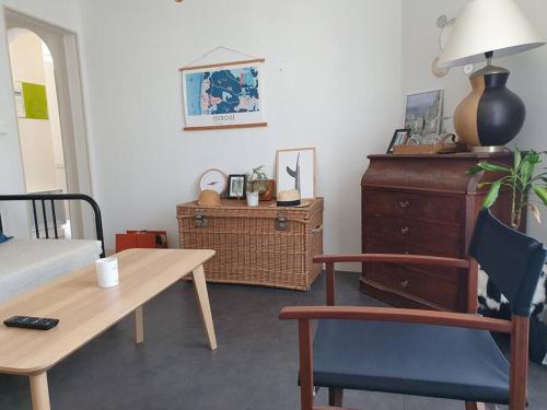 a living room with a table and a chair and a desk at Appartement sur cour privative in Capbreton