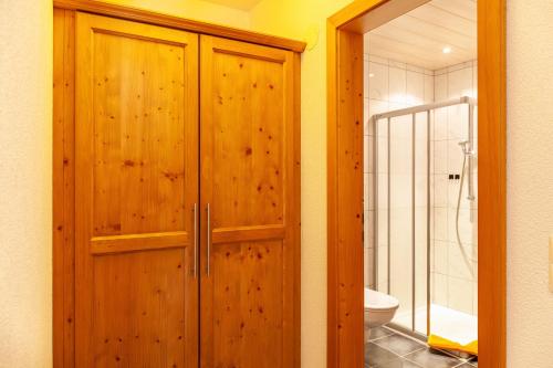 a bathroom with a wooden cabinet and a toilet at Alpenflora 1 in Ischgl