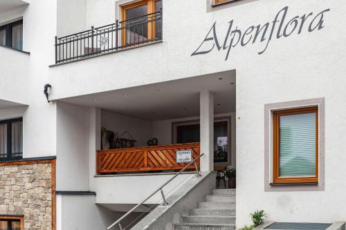 a white building with stairs and a balcony at Alpenflora 2 in Ischgl