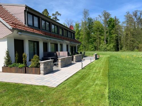 a house with a patio and a lawn at STERK Apartments - idyllisch - modern - stilvoll in Meckenbeuren