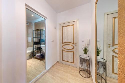 a bathroom with a door and a sink and a mirror at Luxury, sea view, beach, feel good, Flora Beach Resort in Pomorie
