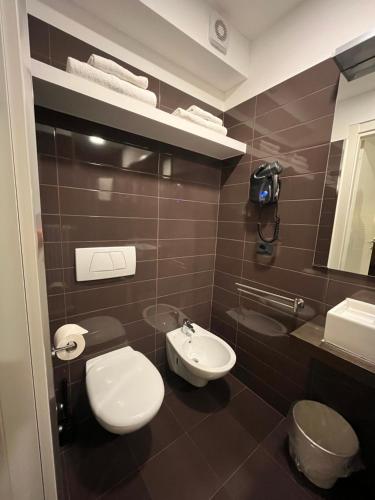 a bathroom with a white toilet and a sink at Hotel Isola Verde in Nago-Torbole