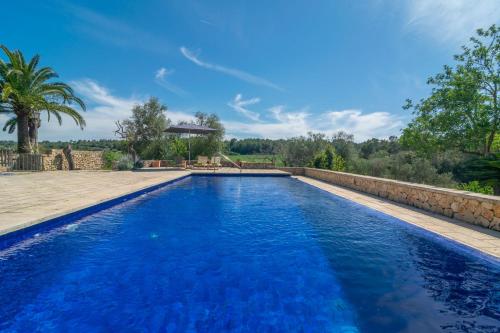 a swimming pool with blue water in a yard at Hortella -Ecofinca- in Sant Joan