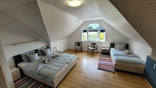 a bedroom with a bed and a couch in a attic at Gyöngyike Apartmanház Vonyarcvashegy in Vonyarcvashegy