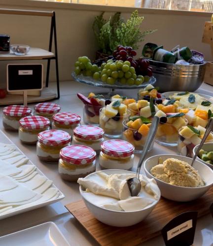 ein Tisch mit Schüsseln voller Essen und Obst in der Unterkunft Apartamentos Aura Park Fira BCN in Hospitalet de Llobregat