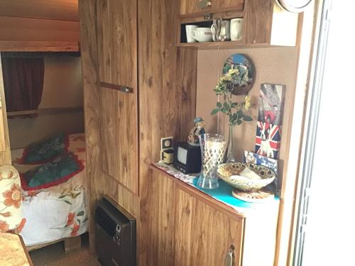 a room with a bed and a cabinet with a table at VINTAGE CARAVANE in Les Attaques