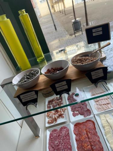 eine Vitrine mit verschiedenen Fleischsorten und Desserts in der Unterkunft Apartamentos Aura Park Fira BCN in Hospitalet de Llobregat