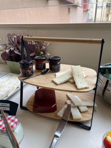 ein Schneidebrett mit Käse, Marmelade und einem Messer in der Unterkunft Apartamentos Aura Park Fira BCN in Hospitalet de Llobregat