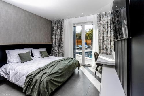sypialnia z łóżkiem i biurkiem oraz balkon w obiekcie Villa Primus w mieście Gostinjac