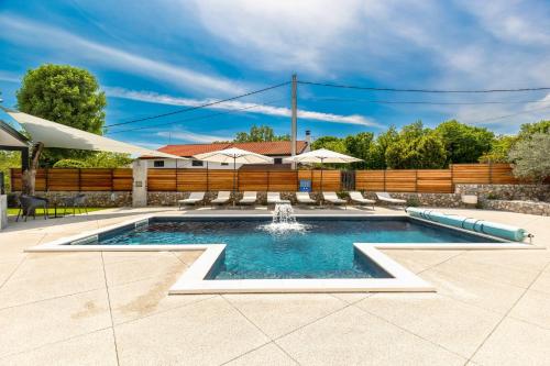 a swimming pool with a fountain in a yard at Villa Primus in Gostinjac