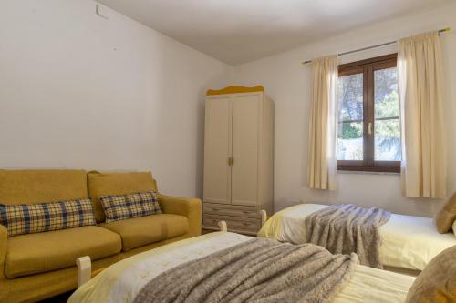 a living room with a couch and two beds at Villa Matian in Marina di Sorso