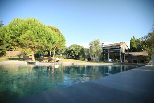 une piscine d'eau avec une maison et des arbres dans l'établissement Maison avec piscine, à Soumensac