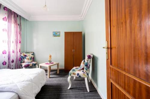 - une chambre avec un lit, une chaise et une porte dans l'établissement Homestay, Private room ,Séjours chez l'habitant Casa Voyageurs, à Casablanca