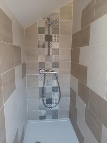 a bathroom with a shower with a shower head at Ancienne maison de pêcheurs in Saint-Marcouf