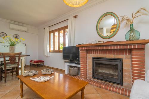 a living room with a fireplace and a table at Can Pilos in Inca