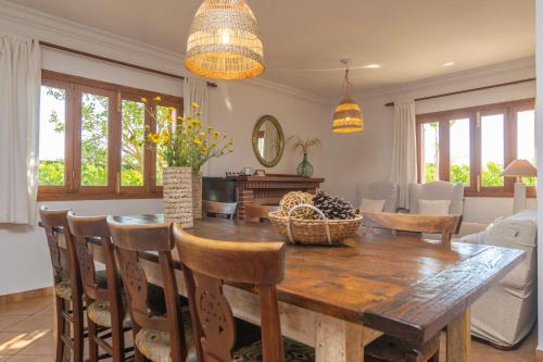 a dining room with a wooden table and chairs at Can Pilos in Inca
