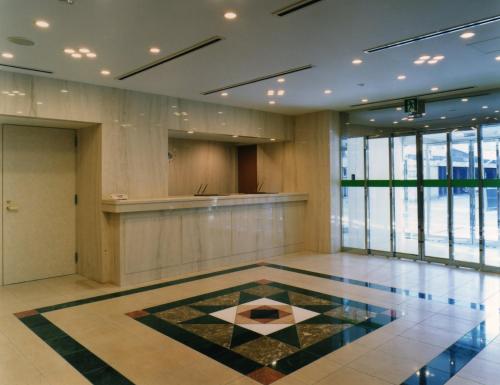 a lobby with a tile floor in a building at Himeji Green Hotel Tatemachi in Himeji