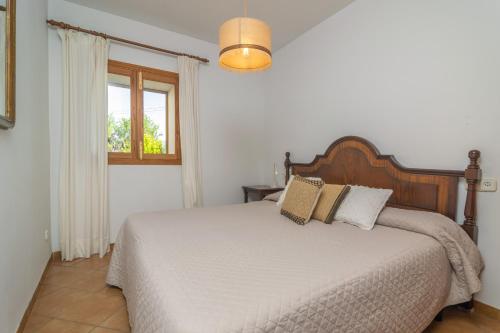a bedroom with a bed and a window at Can Pilos in Inca