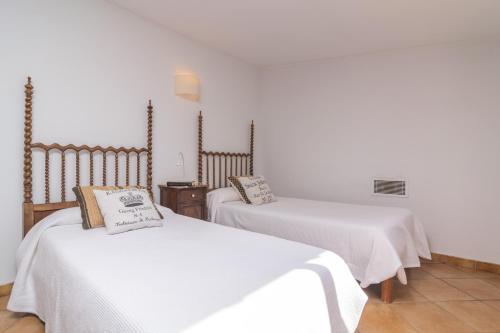 two beds with white sheets in a room at Can Pilos in Inca
