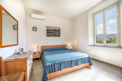 a bedroom with a bed and a mirror and a window at Aethalia - a 300mt dal mare in Marina di Campo