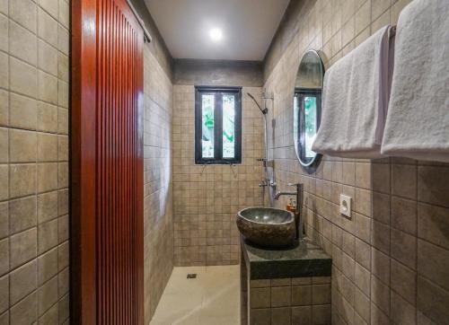 a bathroom with a sink and a mirror and a counter at Daydream Lodge in Tampaksiring