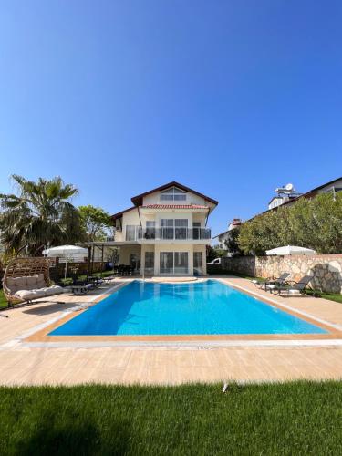 a large swimming pool in front of a house at Villa Valley Oludeniz, 4 Bedroom, Large Swimming Pool in Fethiye