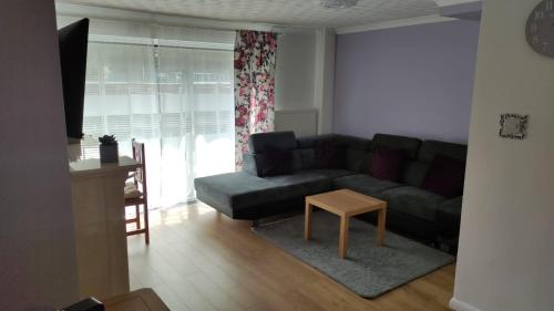 un soggiorno con divano e tavolo di 3 bed house in Walsall, perfect for contractors & leisure & free parking a Walsall