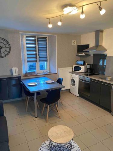 une cuisine avec une table et des chaises dans une cuisine dans l'établissement Chez Flo et Manon, à Balleroy