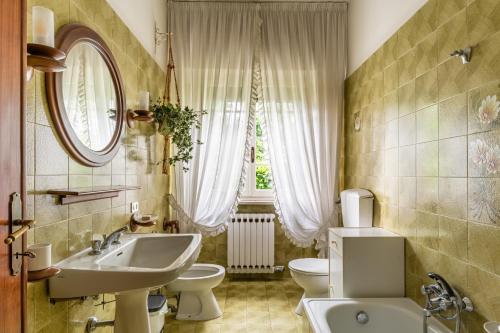 y baño con lavabo, aseo y espejo. en Tea Rose House, en Capannori