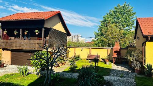 a house with a balcony and a yard with plants at LETO House in Târgu Jiu