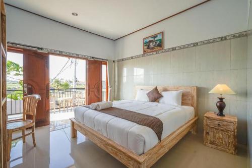 een slaapkamer met een groot bed en een balkon bij Pondok Lulik Seseh Beach in Munggu