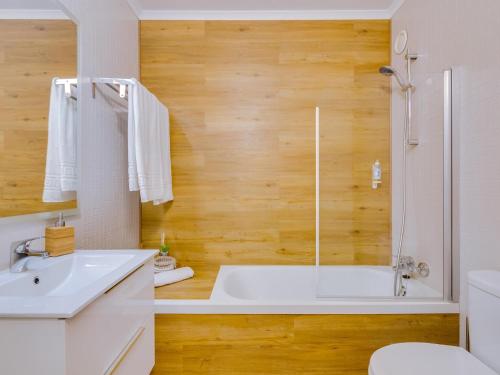 uma casa de banho com uma banheira, um WC e um lavatório. em AL - Be Happy Apartment em Vilamoura