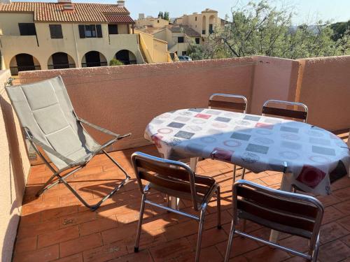 une table et des chaises assises sur un balcon dans l'établissement Appartement avec mezzanine, 4 pers, plage à 250m, parking privé, commerces à proximité - FR-1-81-43, à Port-Leucate