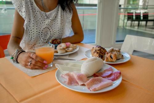 Una donna seduta a un tavolo con piatti di cibo di Hotel Union a Riccione
