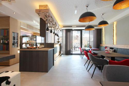 a restaurant with a bar and tables and chairs at AvenidA Mountain Lodges Kaprun in Kaprun