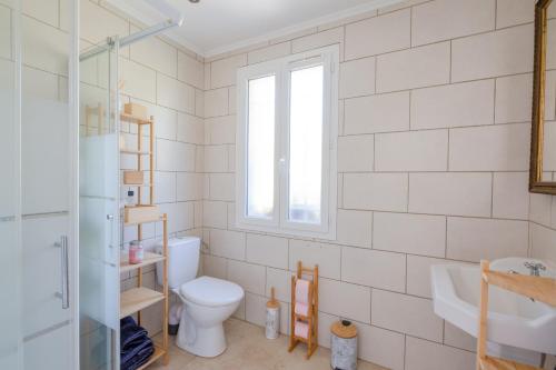 baño con aseo y lavabo y ventana en Le Mas de Georges - Jolie maison avec piscine privée, en Le Thoronet