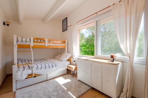 1 dormitorio con litera y ventana en Le Mas de Georges - Jolie maison avec piscine privée, en Le Thoronet