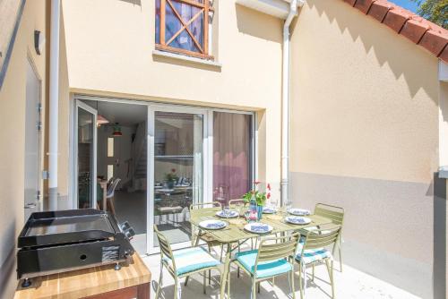 un patio avec une table, des chaises et un barbecue dans l'établissement Bibifoc Baie - au coeur de la Baie de la Somme, à Saint-Valery-sur-Somme
